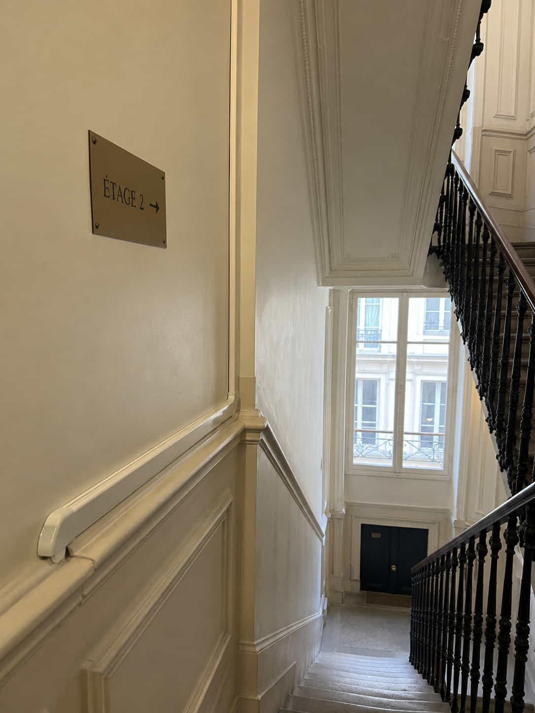 Cheminement discret d'un câble réseau Cat6A en goulotte le long d'une cage d'escalier haussmannienne