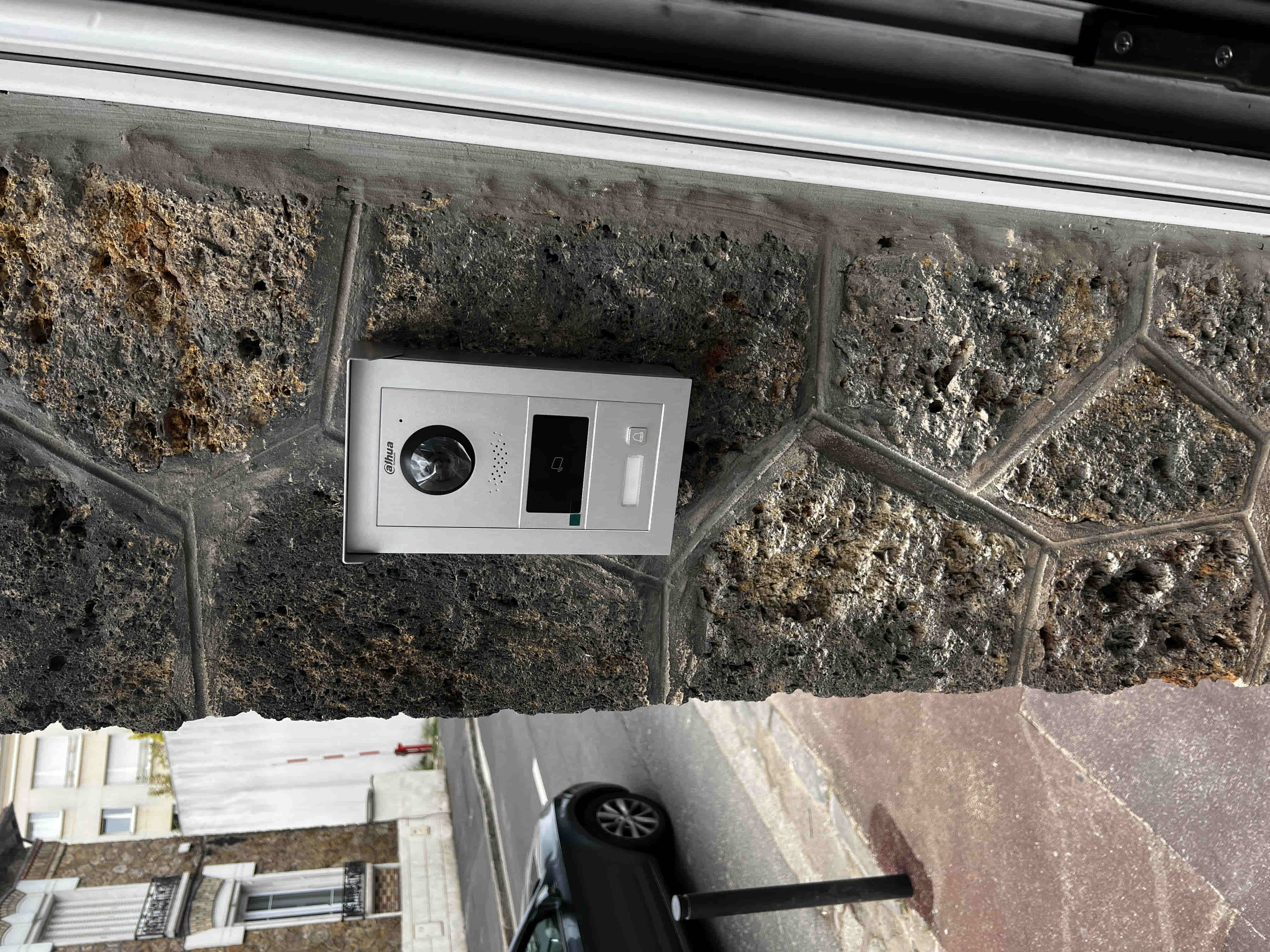 Platine d'interphone vidéo IP installée en entrée d'immeuble professionnel avec lecteur de badge intégré