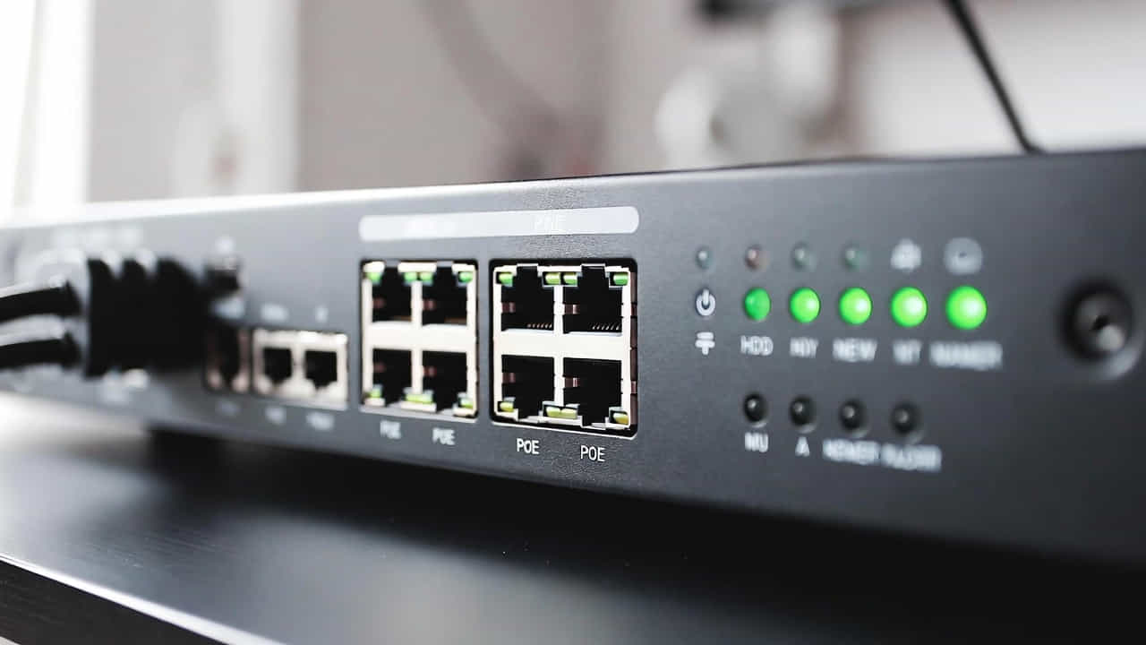 Panneau avant d'un enregistreur NVR IP pour vidéosurveillance avec ports Ethernet RJ45 PoE, câbles branchés à gauche, et voyants LED verts allumés